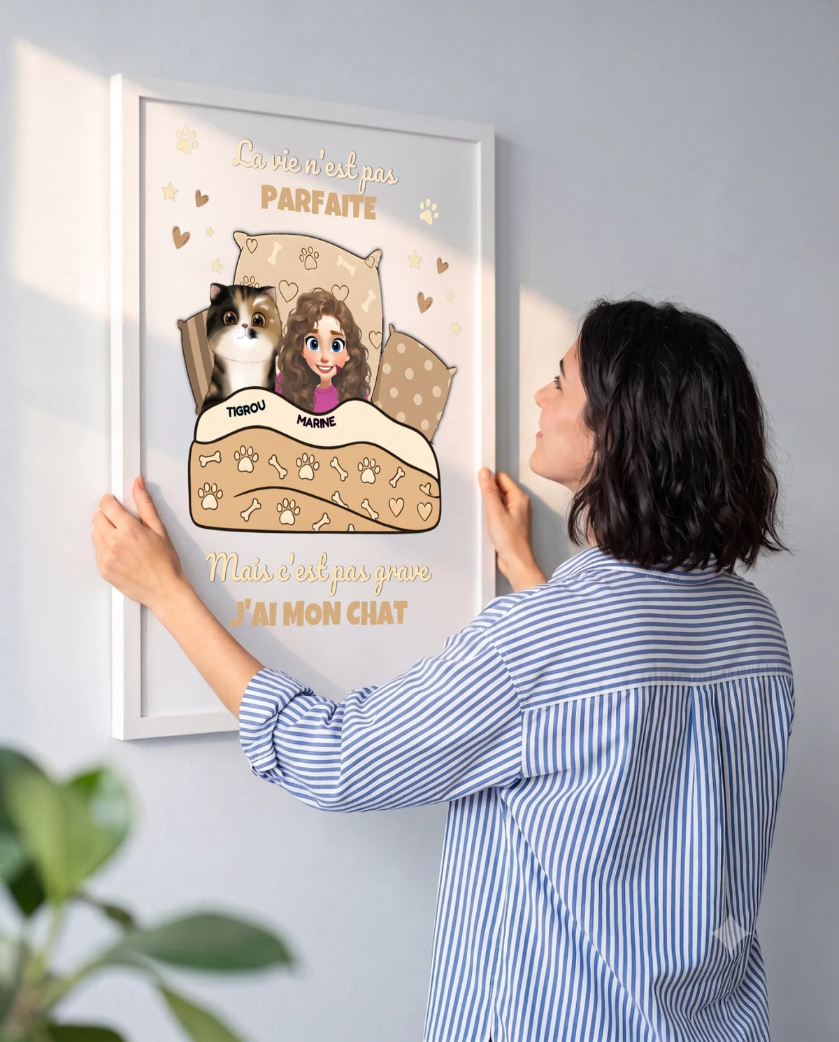 Femme accrochant au mur un poster personnalisé avec le portrait de son chat